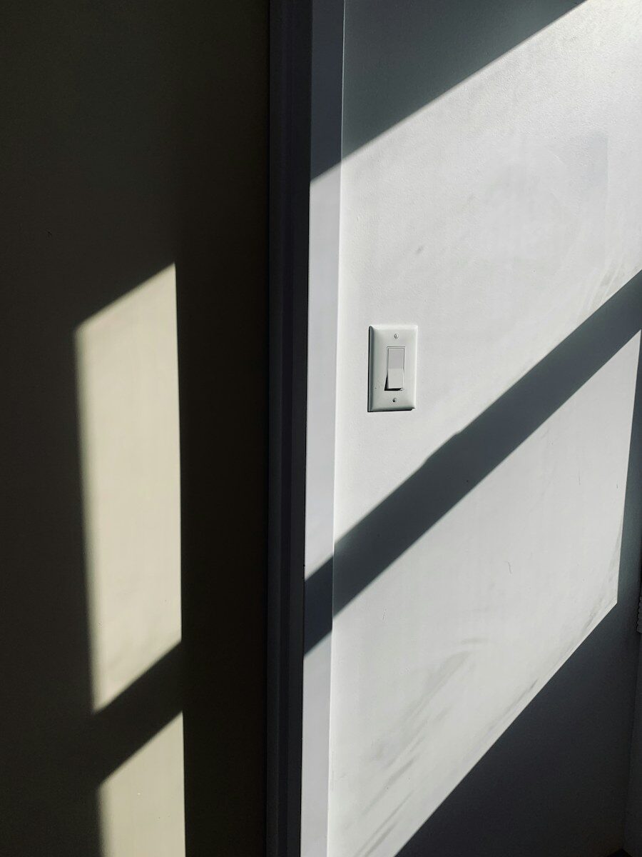 White wall switch beside a door jamb